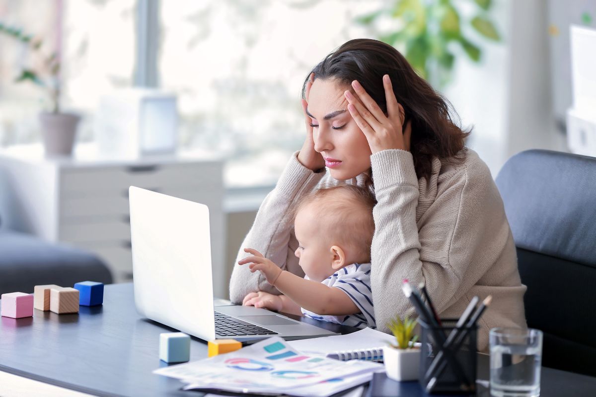 gestresste Frau mit Baby beim Arbeiten